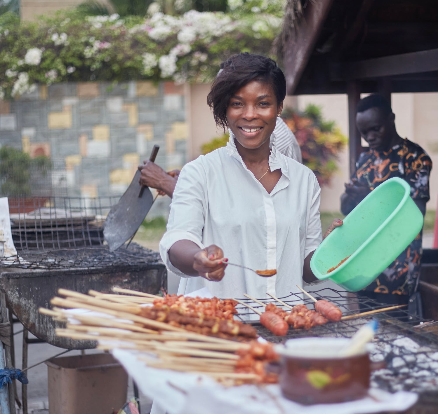 African woman applies African spice blend to meat